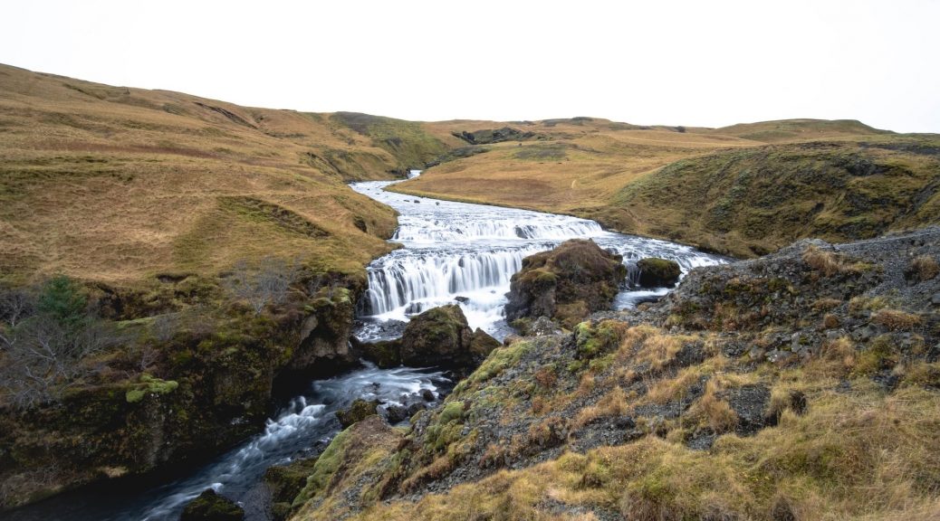 grassland around river and waterfall