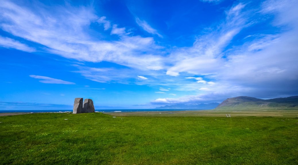 green grass field under blue sky