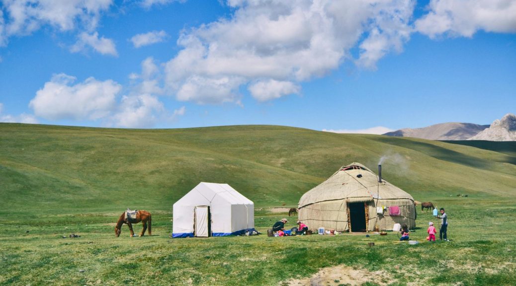 photo of hut and tent on grass field